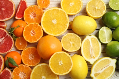 Photo of Different citrus fruits on wooden background, top view