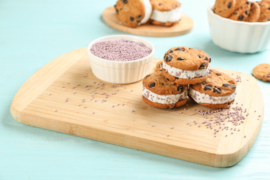 Sweet delicious ice cream cookie sandwiches on light blue wooden table