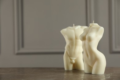 Beautiful male and female body shaped candles on grey table. Space for text
