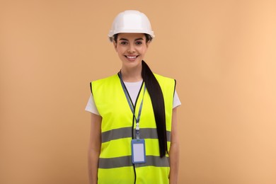 Photo of Engineer with hard hat and badge on beige background