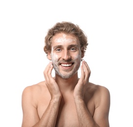 Young man washing face with soap on white background