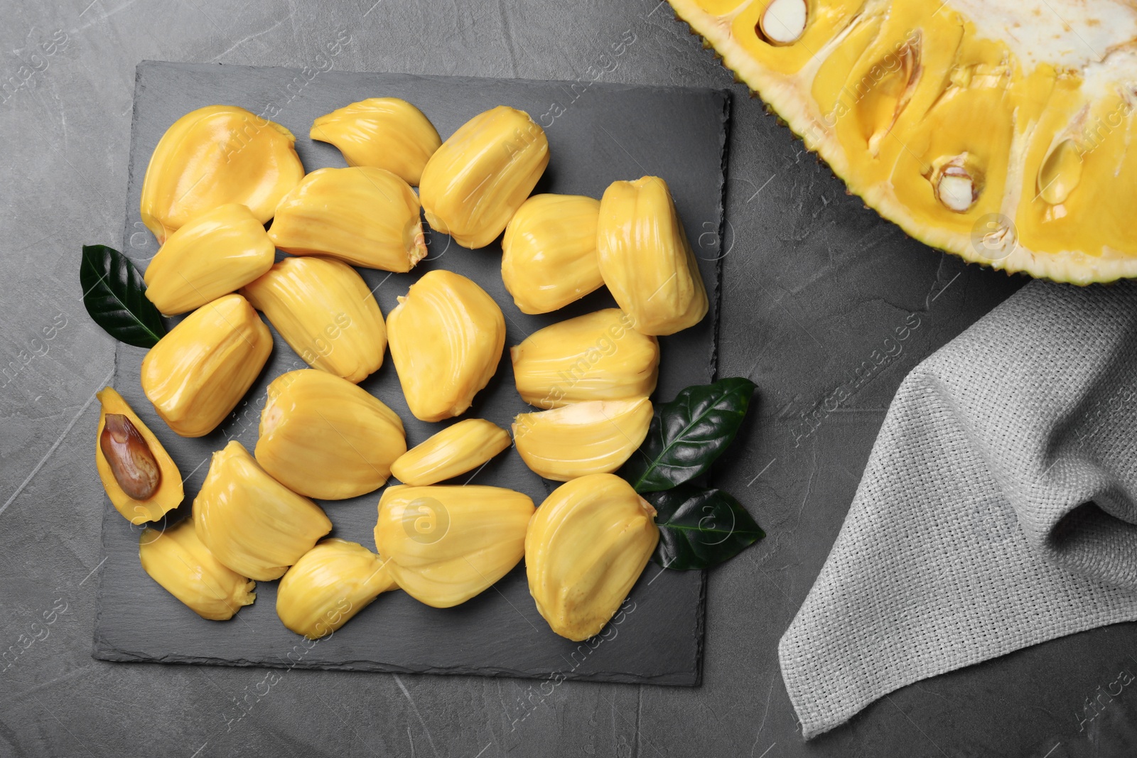 Photo of Delicious exotic jackfruit bulbs on grey table, flat lay