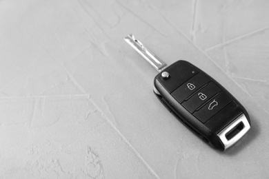 Car key on grey background. Space for text