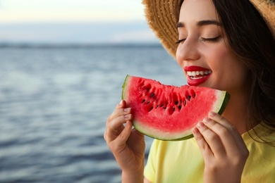 Photo of Beautiful young woman with watermelon near river, closeup