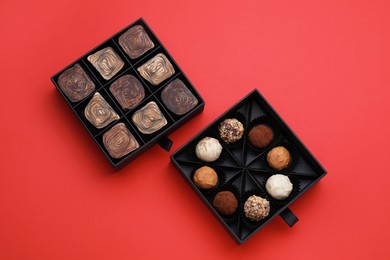 Boxes of tasty chocolate candies on red background, flat lay