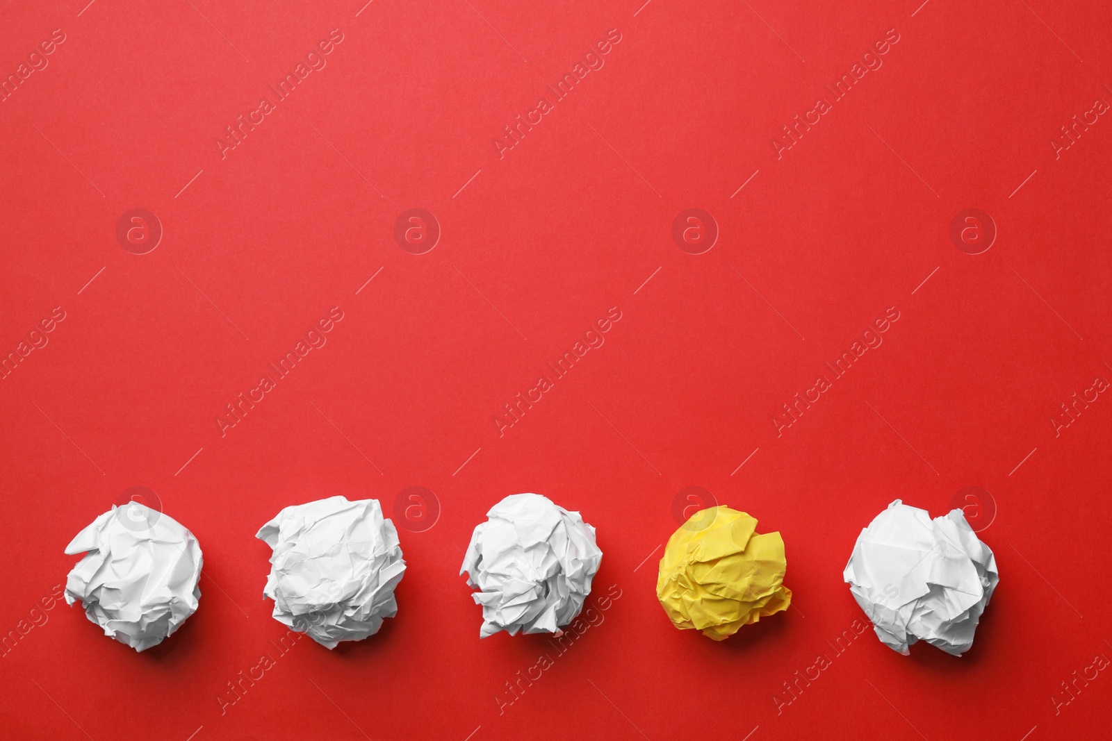 Photo of Yellow sheet of crumpled paper among white ones on color background, flat lay. Space for text