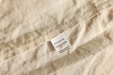 Photo of Clothing label on beige garment, closeup view