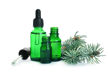 Bottles of essential oil, pipette and pine branch isolated on white