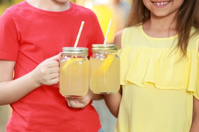 Little girls with natural lemonade, closeup. Summer refreshing drink