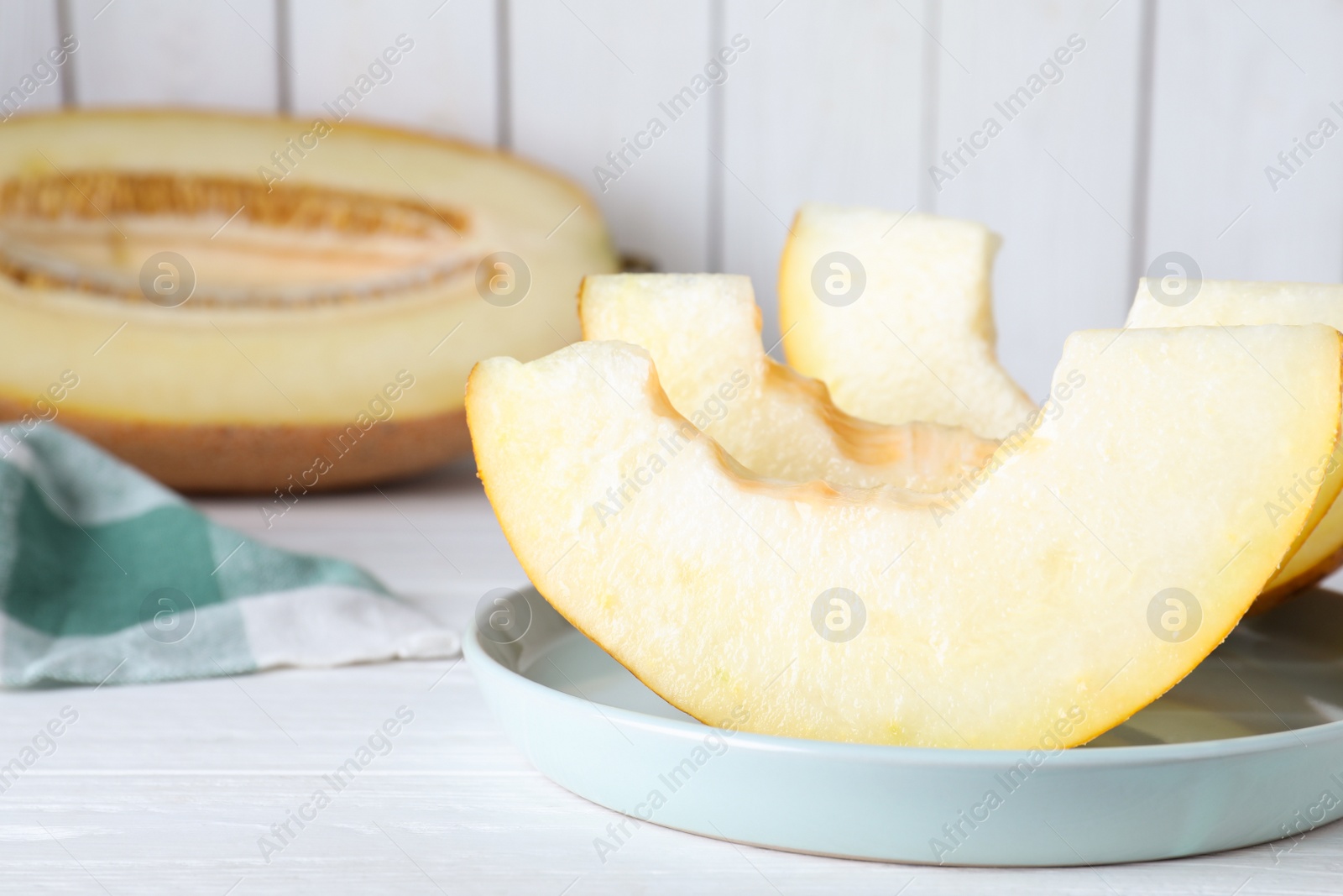 Photo of Slices of delicious ripe melon on white wooden table, closeup