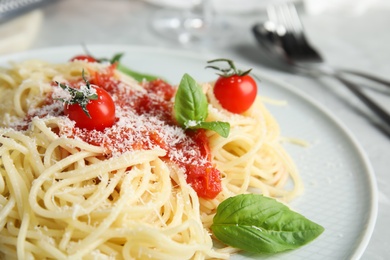 Photo of Tasty pasta with tomatoes, cheese and basil on table, closeup