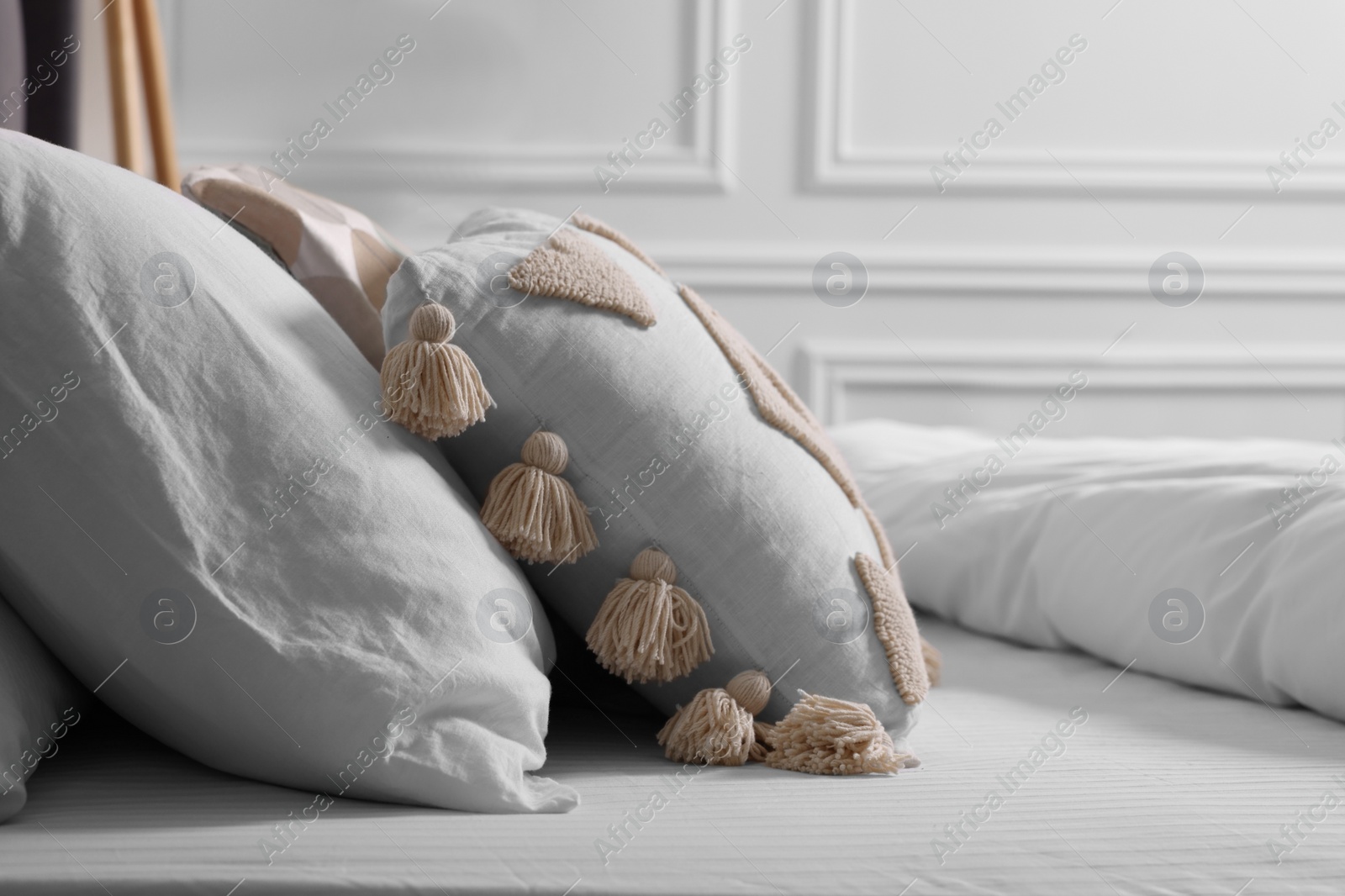 Photo of Comfortable bed with pillows and duvet indoors, closeup. Stylish interior