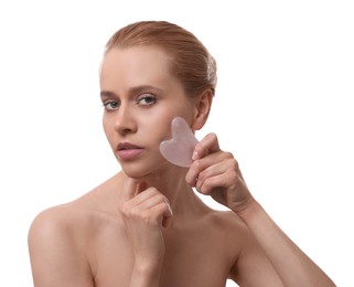 Beautiful young woman doing facial massage with gua sha tool on white background