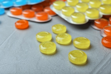 Photo of Color cough drops on grey background, closeup