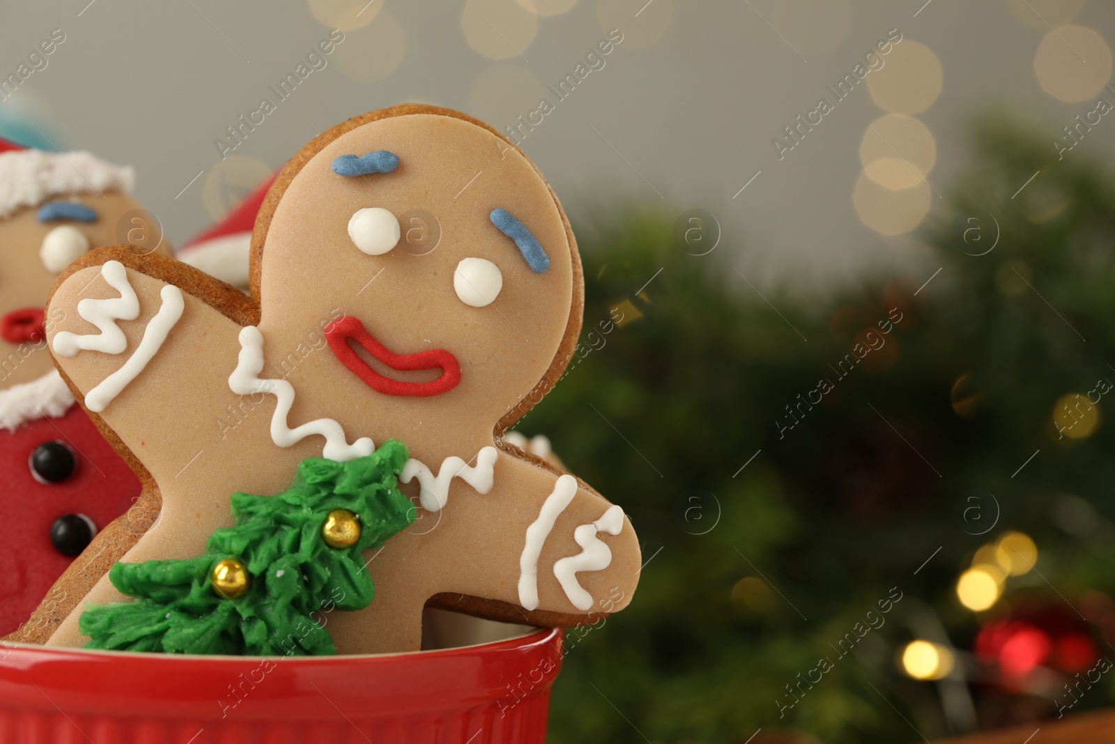 Photo of Delicious homemade Christmas cookies in bowl against blurred festive lights, closeup. Space for text