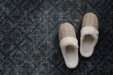Photo of Pair of beautiful soft slippers on carpet, top view. Space for text