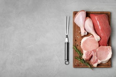 Photo of Flat lay composition with fresh raw meat and space for text on gray background