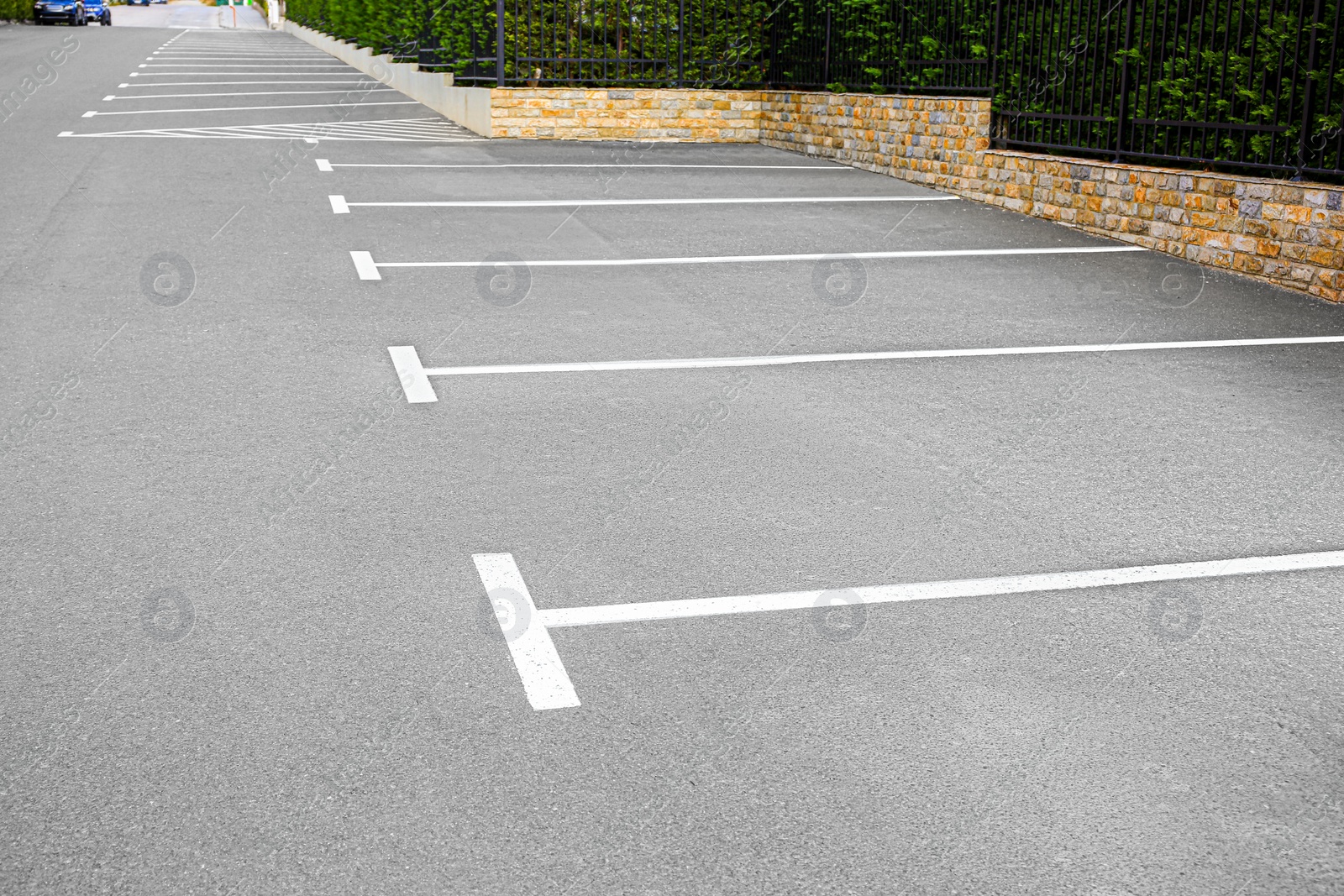 Photo of Empty outdoor parking lot with painted markings on asphalt