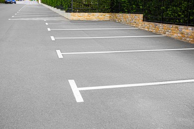 Photo of Empty outdoor parking lot with painted markings on asphalt