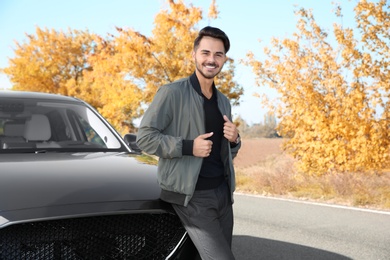 Young man near modern car on sunny day, outdoors