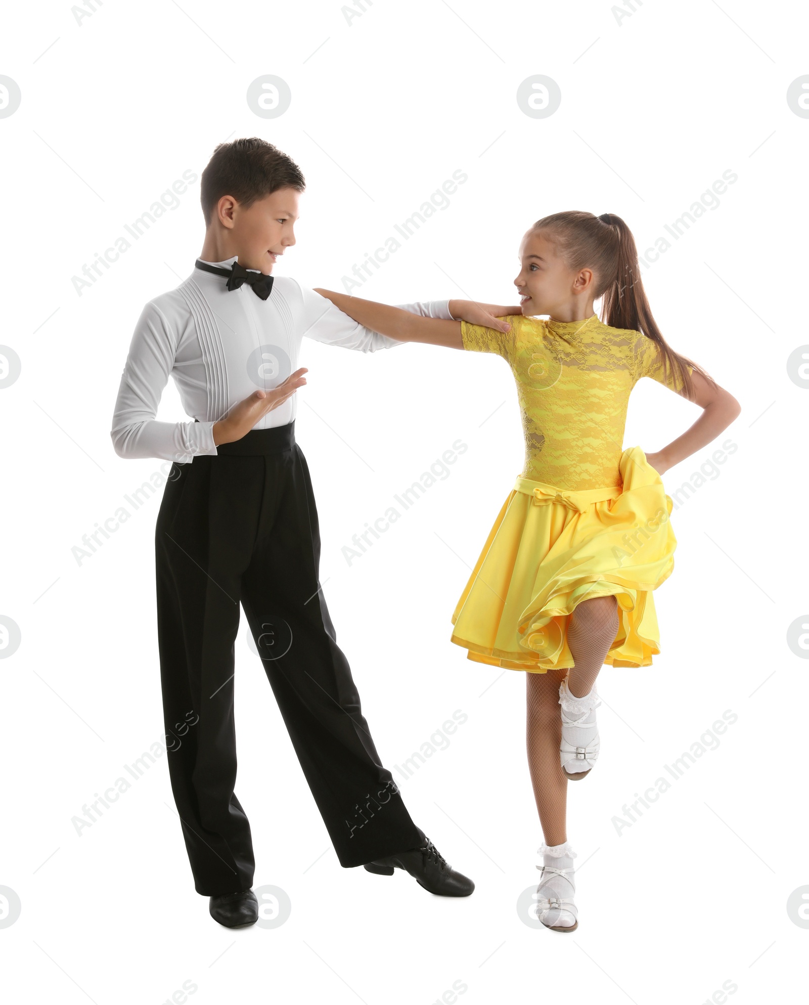 Photo of Beautifully dressed couple of kids dancing on white background