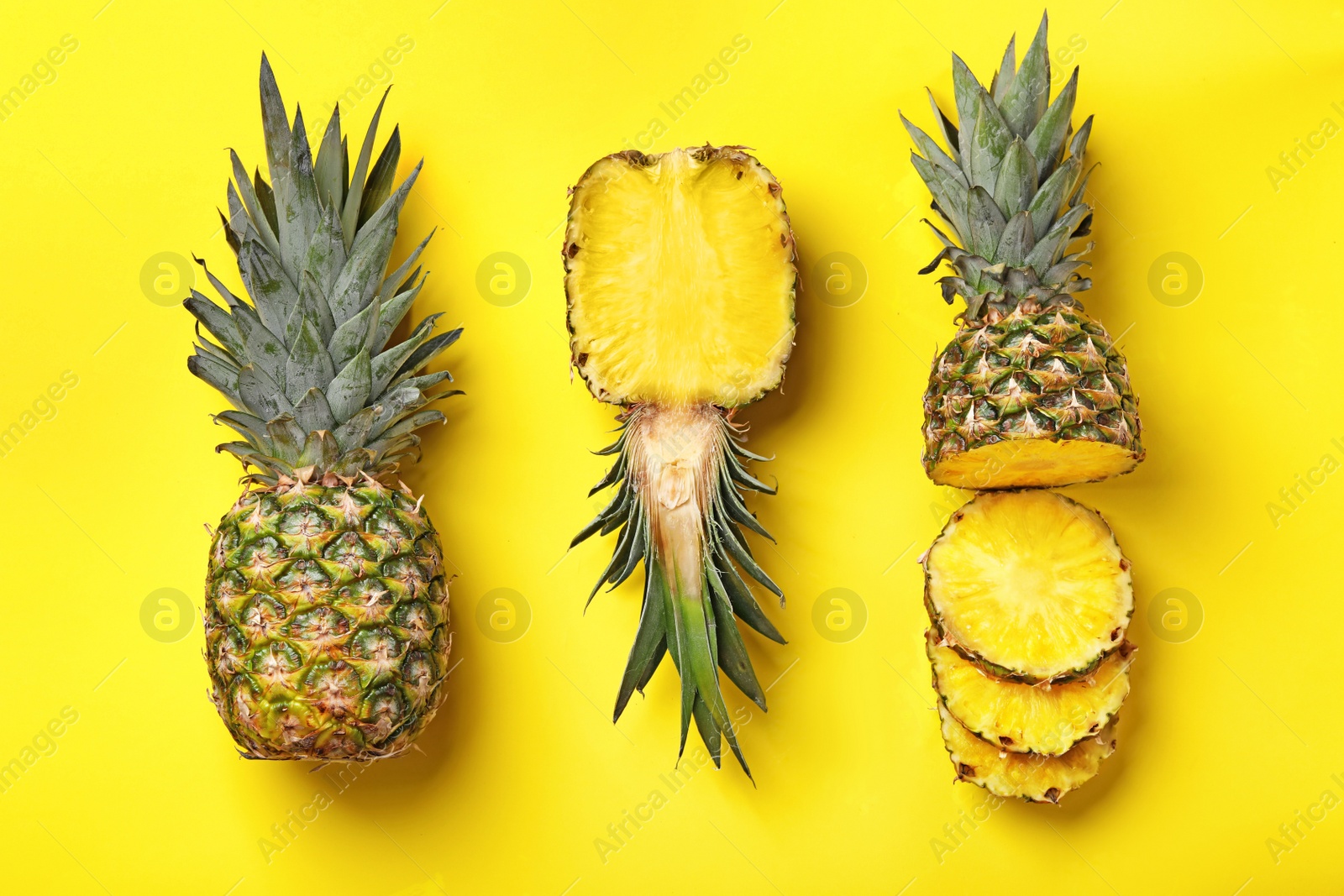 Photo of Flat lay composition with cut and fresh juicy pineapples on color background