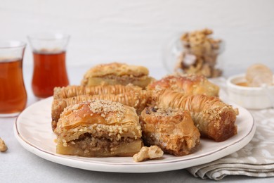 Photo of Eastern sweets. Pieces of tasty baklava on white table, closeup