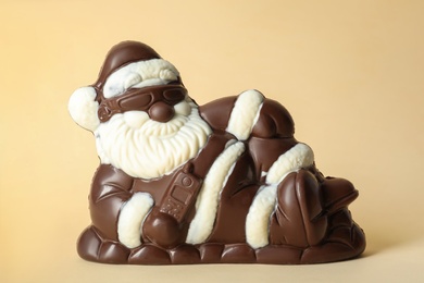 Sweet chocolate Santa Claus candy on beige background