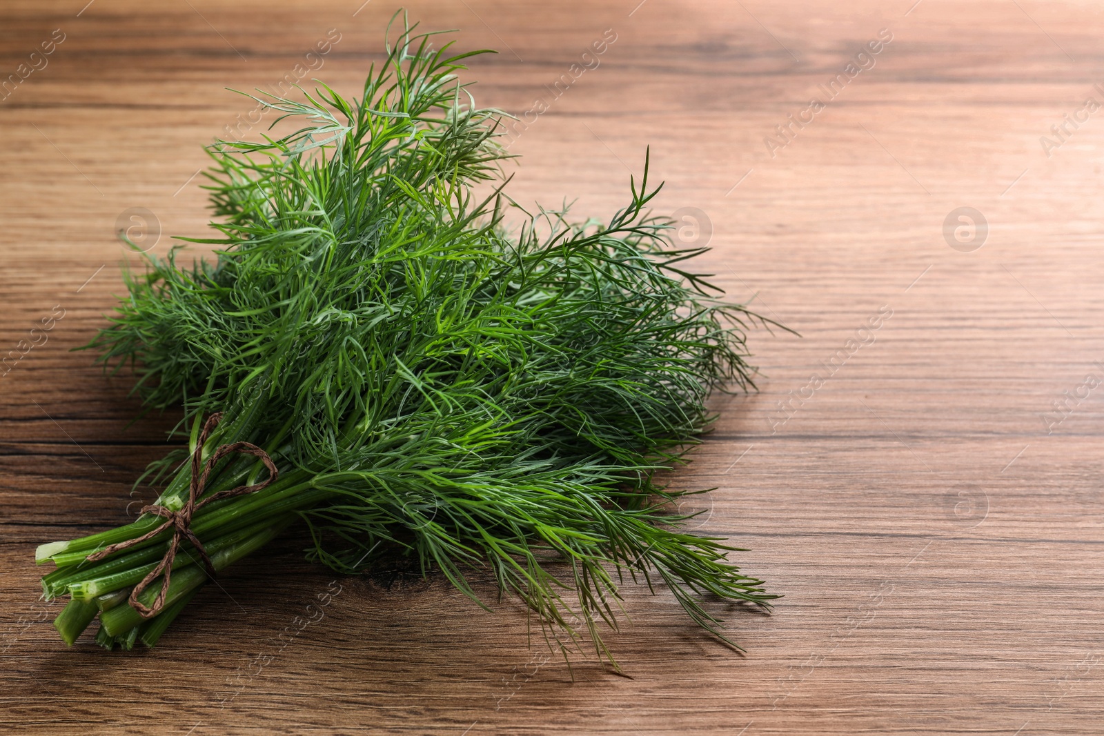 Photo of Bunch of fresh dill on wooden table. Space for text