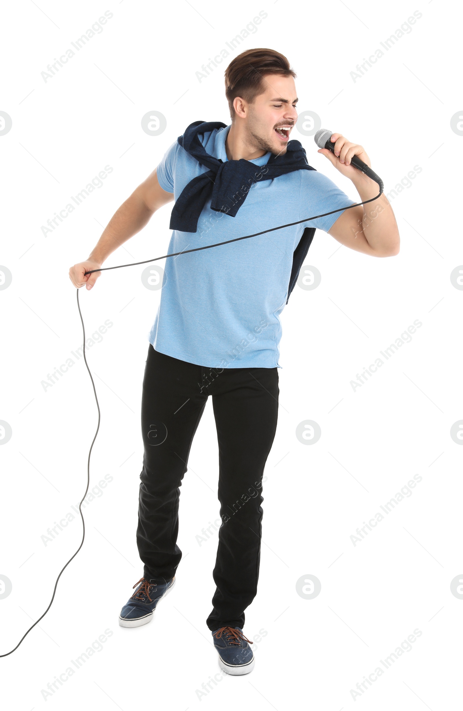 Photo of Young handsome man in casual clothes singing with microphone on white background