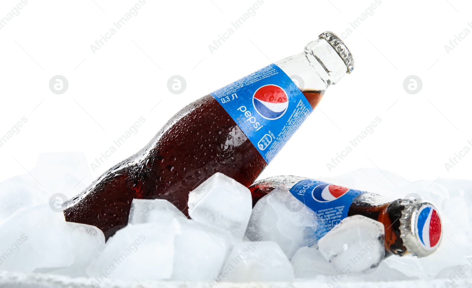 Photo of MYKOLAIV, UKRAINE - FEBRUARY 11, 2021: Glass bottles of Pepsi on ice cubes against white background