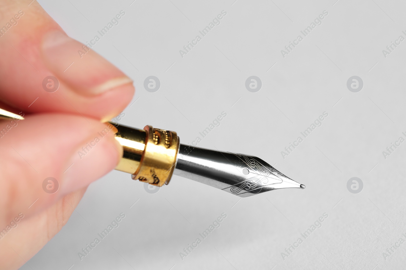 Photo of Woman with fountain pen above white paper, closeup