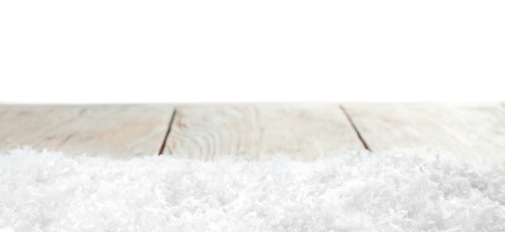 Heap of snow on wooden table against white background. Christmas season