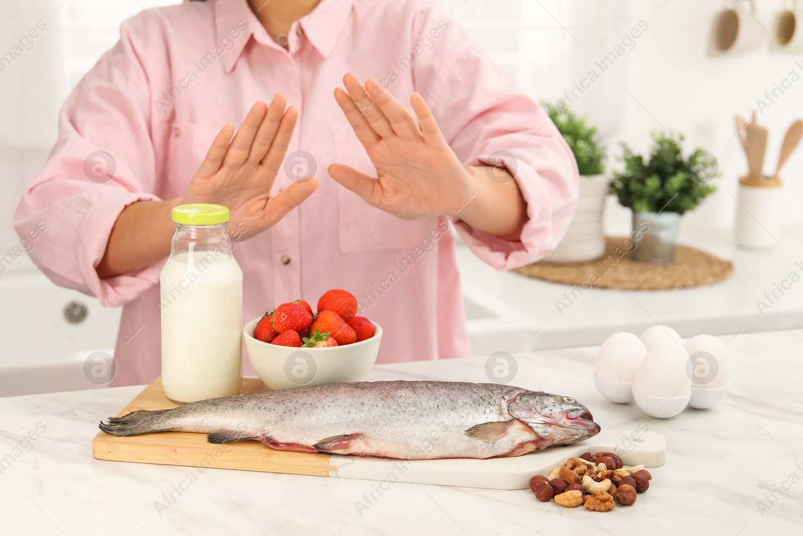 Photo of Woman suffering from food allergies refusing eat different fresh products at light table indoors, closeup