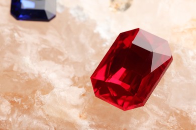 Photo of Beautiful red gemstone for jewelry on mineral surface, closeup. Space for text