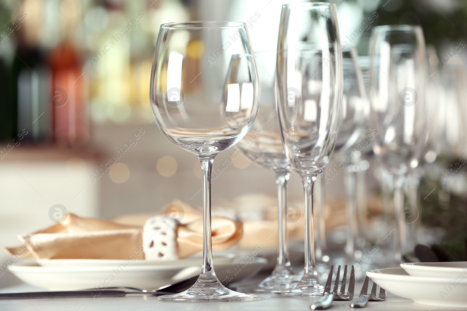 Photo of Table setting with empty glasses, plates and cutlery indoors