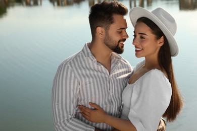 Romantic date. Beautiful couple spending time together near lake