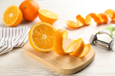 Photo of Orange fruit with peel on white wooden table