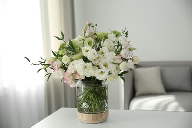 Photo of Bouquet of beautiful flowers on table in living room. Interior design