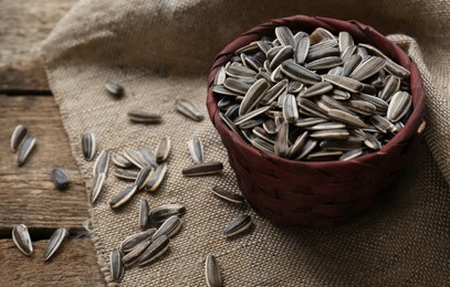 Photo of Organic sunflower seeds on wooden table. Space for text