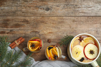 Photo of Aromatic mulled wine on wooden table, flat lay. Space for text