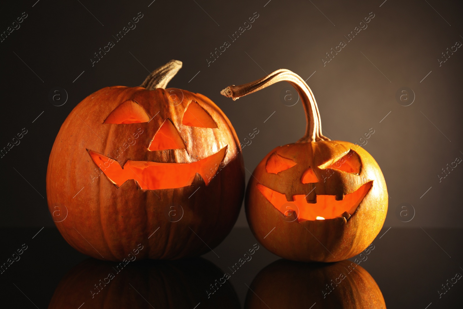 Photo of Halloween pumpkin heads. Glowing jack lanterns on dark background