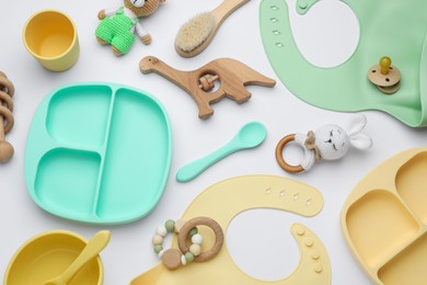 Composition with baby accessories and bibs on white background, top view