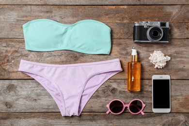 Photo of Flat lay composition with beach objects and mobile phone on wooden background