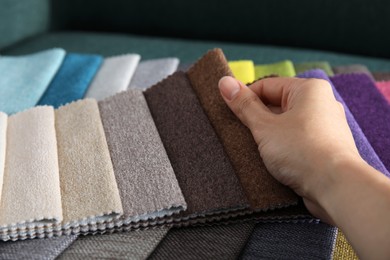 Photo of Woman choosing fabric among colorful samples, closeup