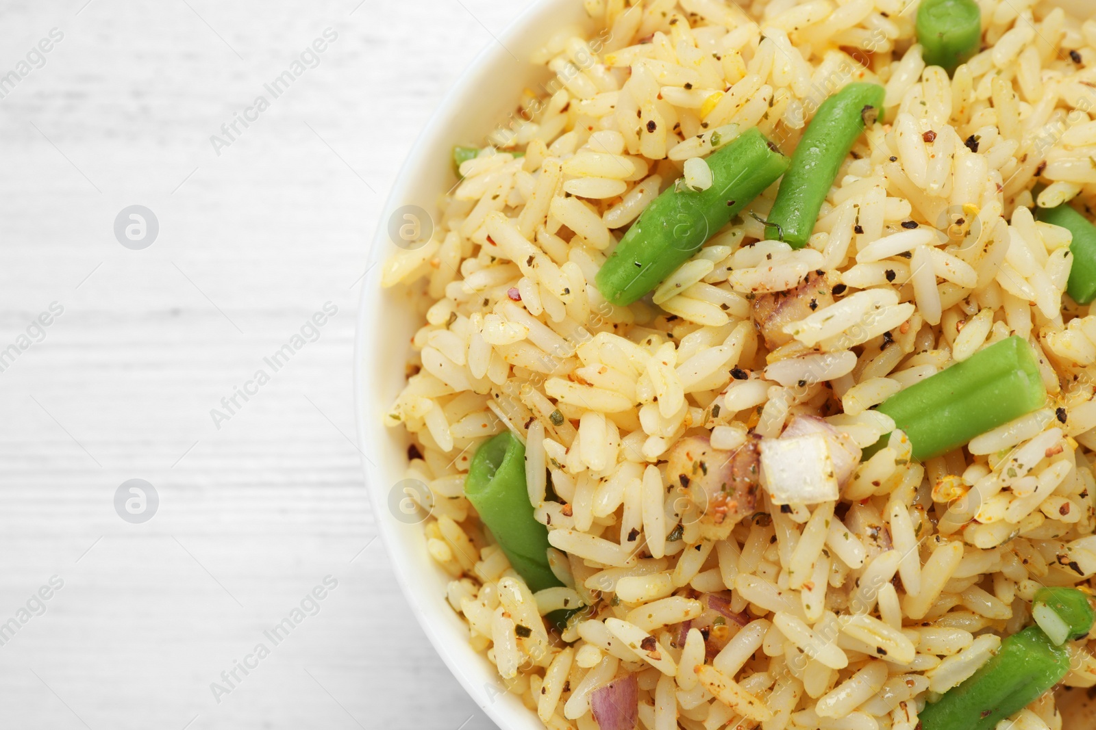 Photo of Tasty rice pilaf with vegetables on white table, top view