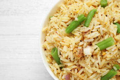 Photo of Tasty rice pilaf with vegetables on white table, top view