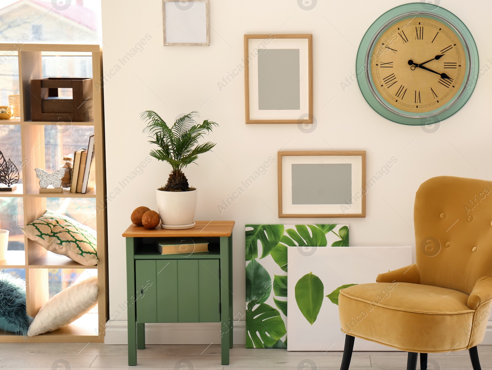 Photo of Tropical plant with green leaves and comfortable armchair in room interior