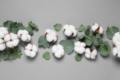 Photo of Cotton flowers and eucalyptus leaves on grey background, flat lay