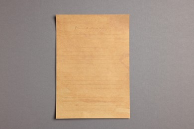 Photo of Sheet of old parchment paper on grey background, top view